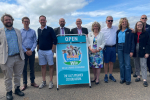 In a floral blue and white summery frock, Anna Firth MP stands with her fellow Southend MP Sir James Duddridge and a number of other men on Southend's seafront