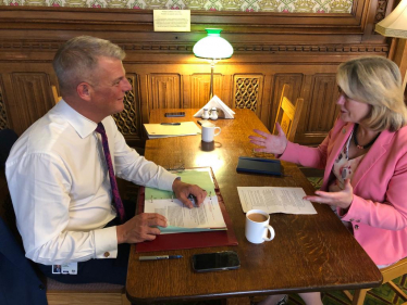 Wearing a floral spring dress and a summery pink jacket, Anna Firth meets with the Sports Minister Stuart Andrew, soberly dressed in a white shirt and tie